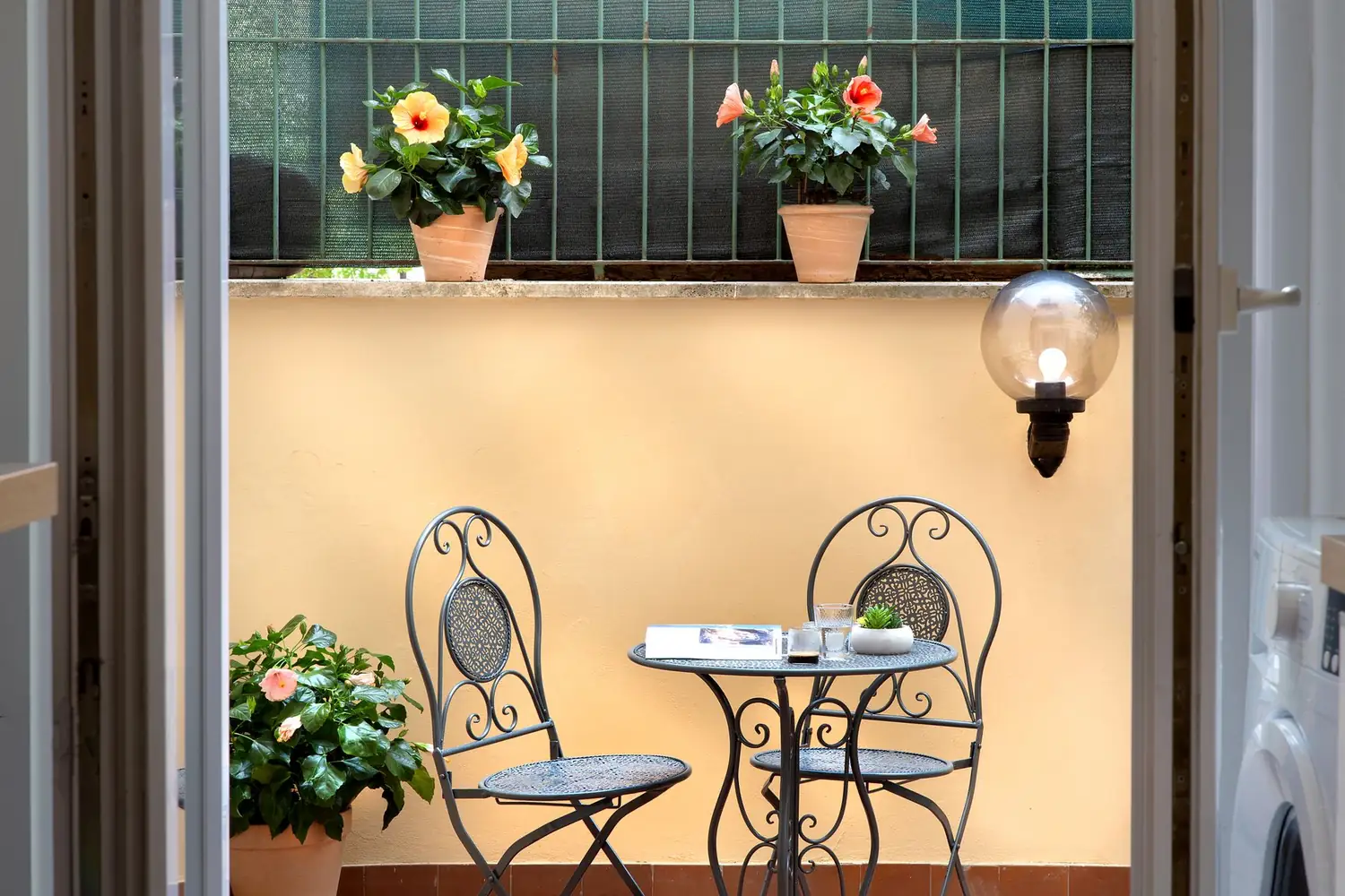 Il tavolino in ferro battuto sul terrazzo, con gli ibiscus in fiore
